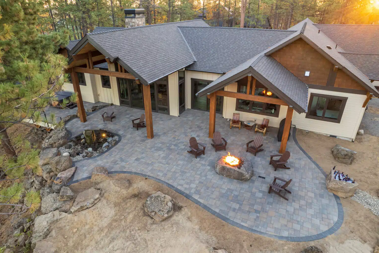 Leiden Stone Collection Concrete Pavers Patio Luxury House with Wood Accents, firepit, and chairs