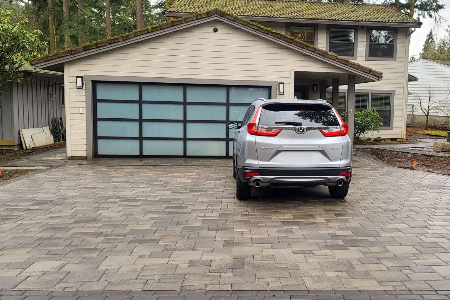 Leiden Stone Collection Concrete Pavers Driveway Cambridge Blend Color SUV and Blue Garage door