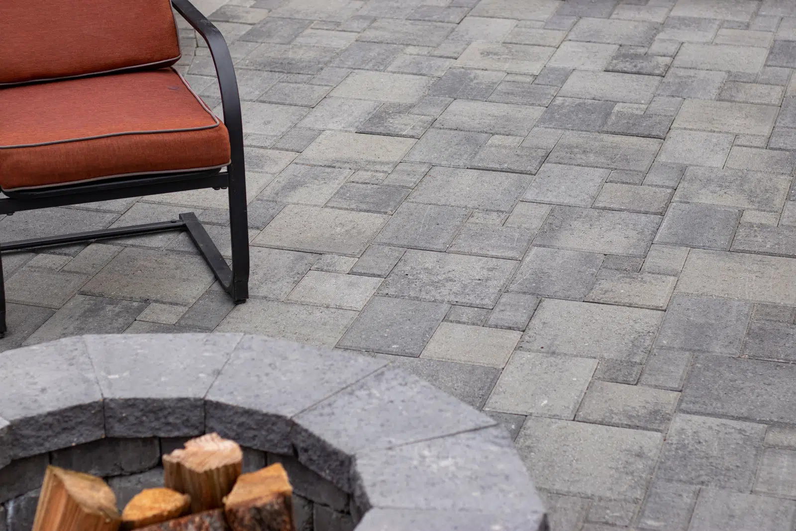 Leiden Stone Collection Concrete Cambridge Blend Color Pavers Firepit with chair and